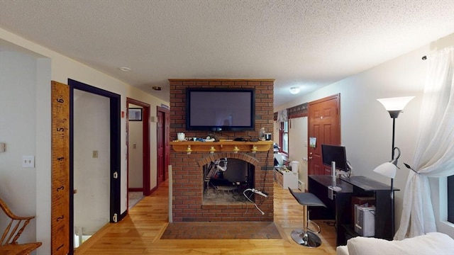 330 Arbor St, Lunenburg, MA 01462 - living area featuring wood finished floors, a textured ceiling, and a brick fireplace