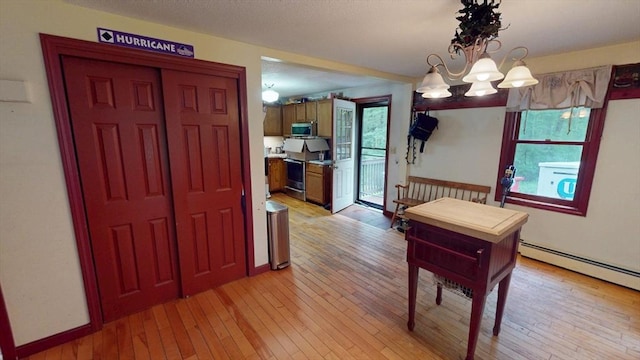 330 Arbor St, Lunenburg, MA 01462 - dining area featuring light wood-type flooring, baseboard heating, and a chandelier