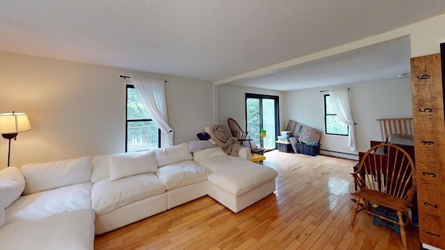 330 Arbor St, Lunenburg, MA 01462 - living area with light wood-type flooring, baseboard heating, and a textured ceiling