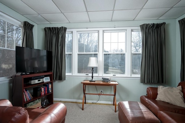 carpeted living room featuring a drop ceiling