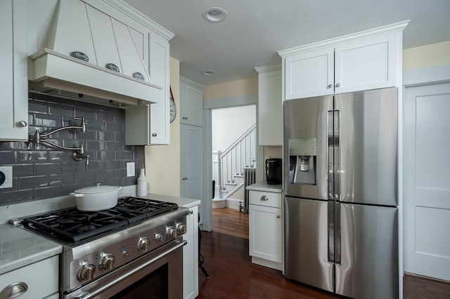 kitchen featuring backsplash, dark wood finished floors, light countertops, appliances with stainless steel finishes, and white cabinets