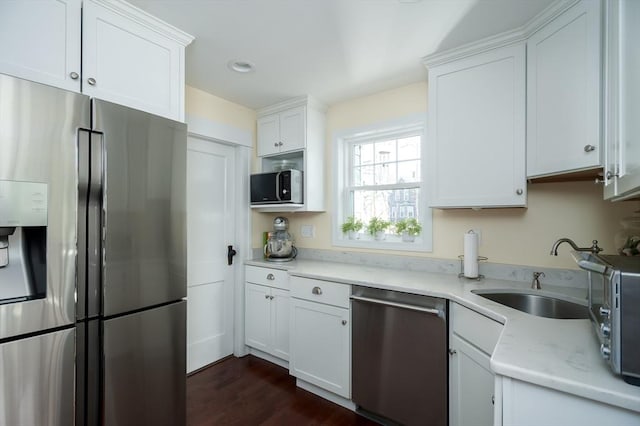 kitchen with a sink, white cabinets, dark wood-style floors, and stainless steel appliances