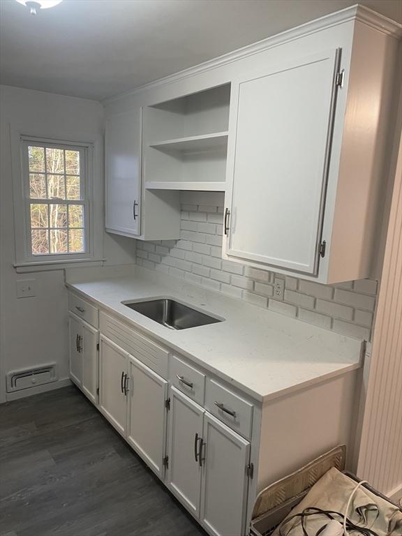 kitchen featuring backsplash, light countertops, dark wood-style floors, white cabinets, and open shelves