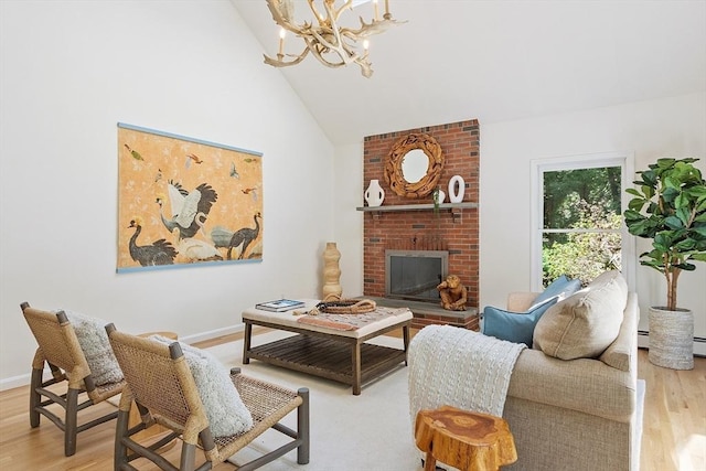 living area featuring a brick fireplace, wood finished floors, high vaulted ceiling, baseboards, and a notable chandelier