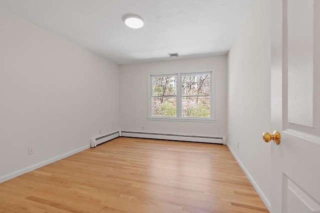 unfurnished room with baseboards, a baseboard heating unit, light wood-style flooring, and visible vents