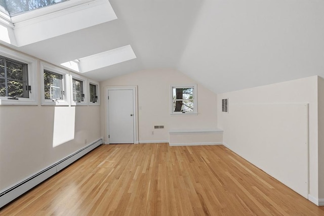 bonus room featuring a baseboard heating unit, vaulted ceiling with skylight, visible vents, and light wood-type flooring