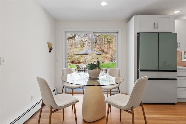 dining room with recessed lighting, baseboard heating, and light wood-style flooring