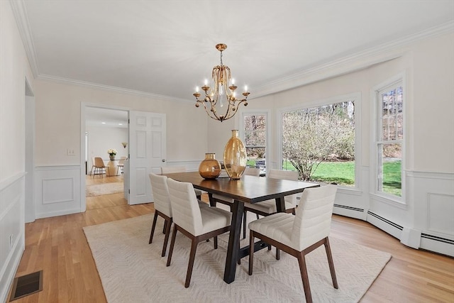 dining space with a chandelier, light wood-style floors, visible vents, and a decorative wall