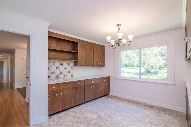 53 Iduna Ln, Amherst, MA 01002 - kitchen with open shelves, a chandelier, tasteful backsplash, light countertops, and hanging light fixtures