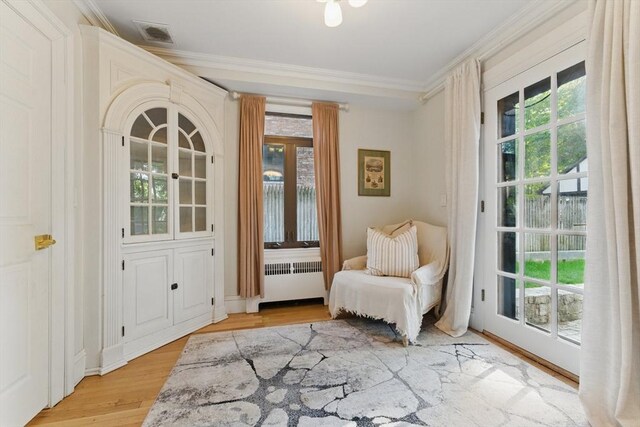 15 Park Ave, Newton, MA 02458 - sitting room with radiator heating unit, ornamental molding, and light wood-style floors