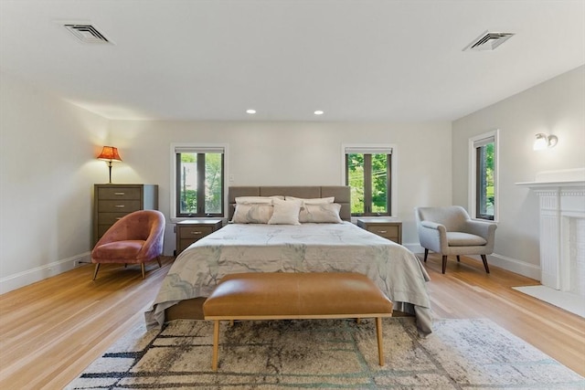 15 Park Ave, Newton, MA 02458 - bedroom with light wood finished floors, baseboards, recessed lighting, and a fireplace with flush hearth