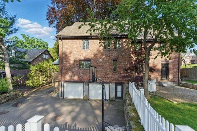 15 Park Ave, Newton, MA 02458 - rear view of house with an attached garage, brick siding, and driveway