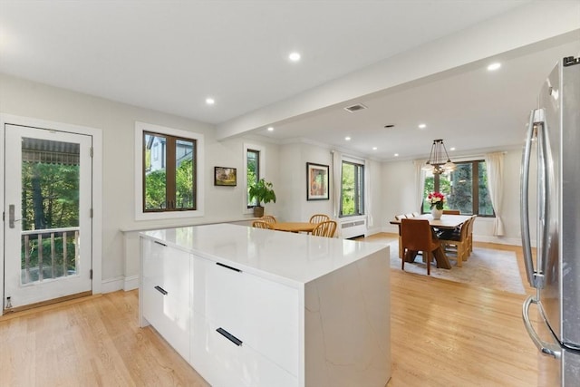 15 Park Ave, Newton, MA 02458 - kitchen featuring freestanding refrigerator, light wood-style flooring, a center island, white cabinetry, and modern cabinets