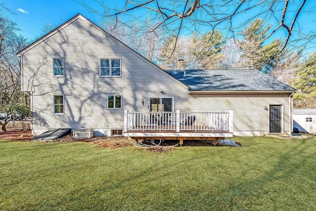 rear view of house with a yard, a chimney, and a wooden deck