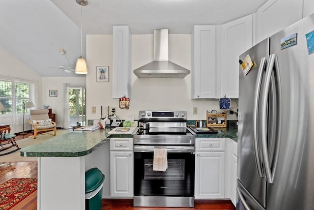 kitchen featuring appliances with stainless steel finishes, a peninsula, white cabinets, and wall chimney range hood