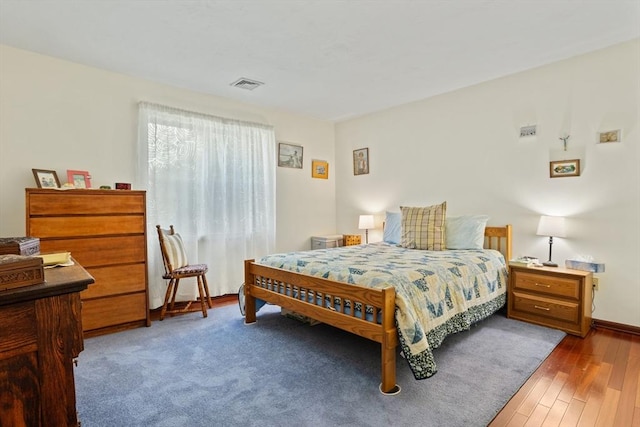 bedroom with visible vents and wood finished floors