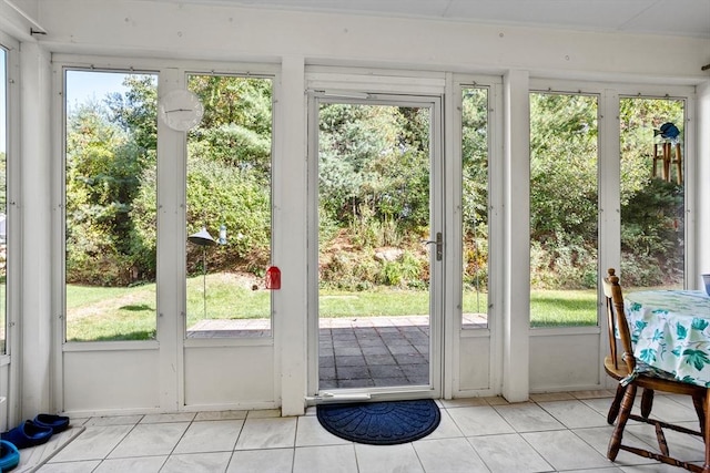 doorway to outside with light tile patterned floors and a sunroom