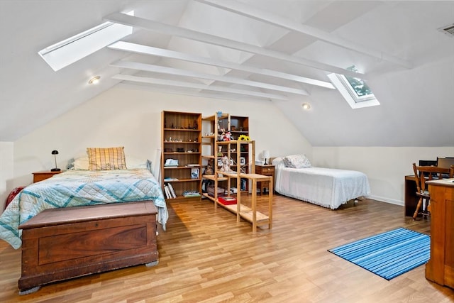 bedroom with vaulted ceiling with skylight, wood finished floors, and visible vents