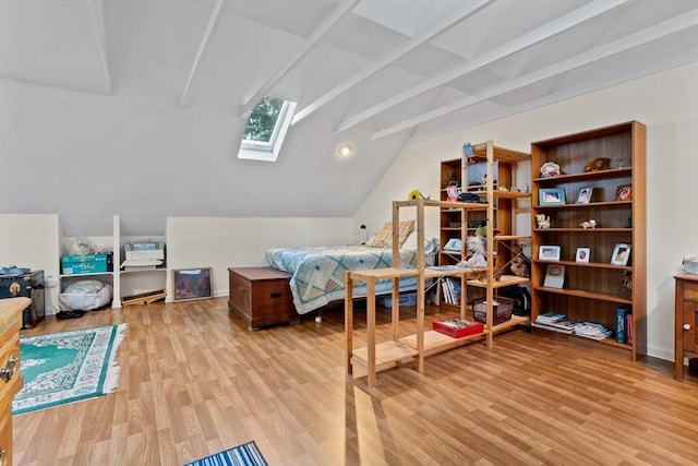 bedroom with lofted ceiling with skylight and wood finished floors