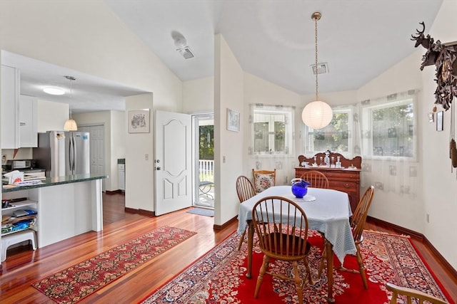 dining area featuring baseboards, light wood-type flooring, lofted ceiling, and visible vents