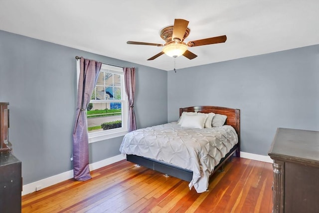 bedroom with a ceiling fan, baseboards, and hardwood / wood-style floors