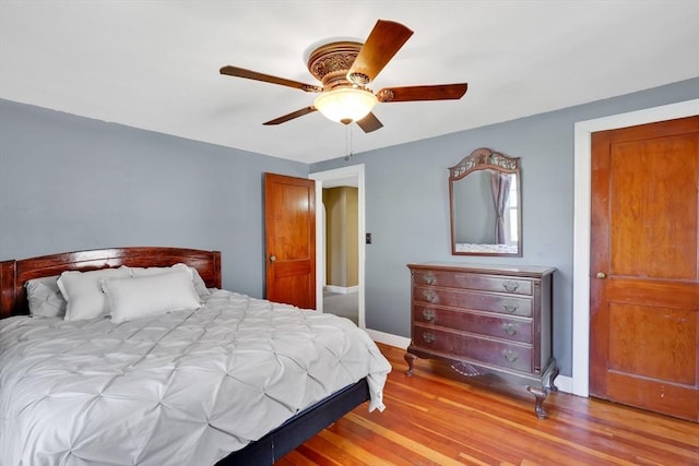 bedroom with baseboards, ceiling fan, and light wood finished floors