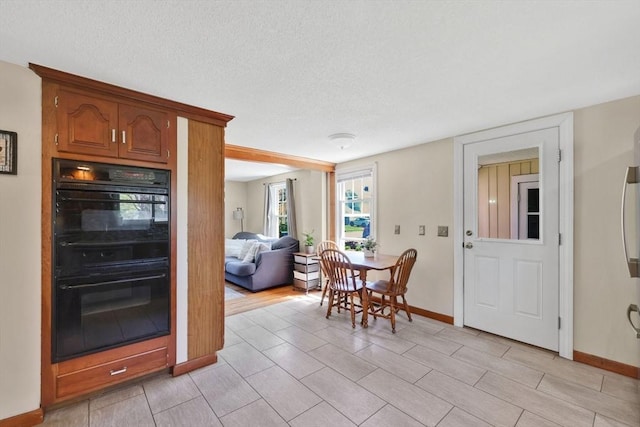 dining area featuring baseboards and a textured ceiling