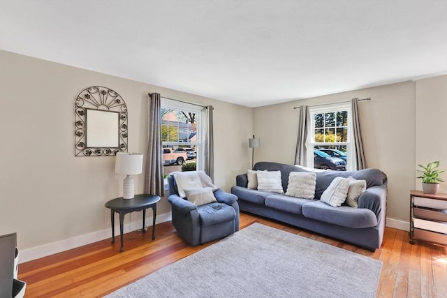 living area featuring baseboards and hardwood / wood-style flooring