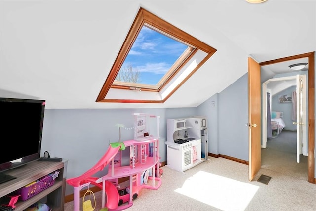 game room featuring carpet floors, lofted ceiling with skylight, and visible vents