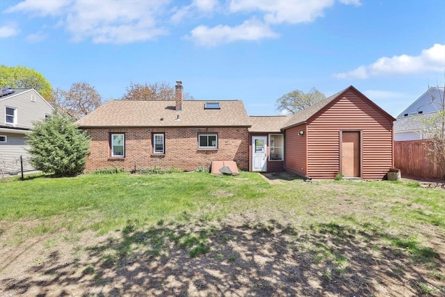back of house with fence, a yard, roof with shingles, and brick siding