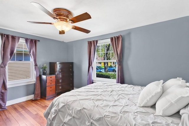 bedroom featuring baseboards, a ceiling fan, and light wood finished floors