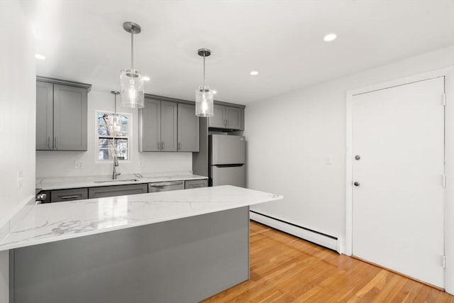 kitchen with a baseboard radiator, appliances with stainless steel finishes, gray cabinets, and sink