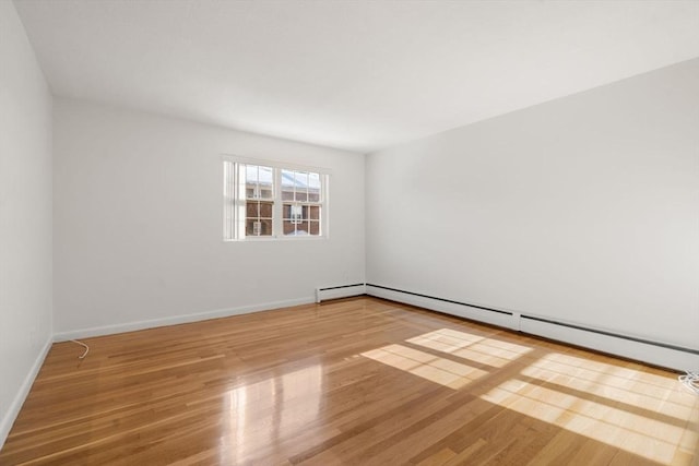 empty room with wood-type flooring and a baseboard radiator