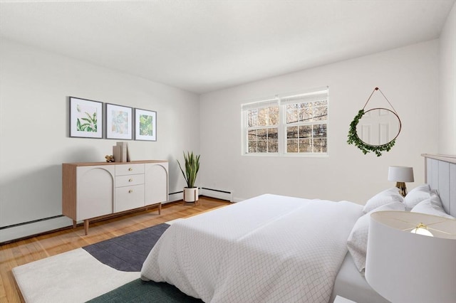 bedroom with a baseboard radiator and light wood-type flooring