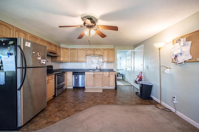 kitchen featuring under cabinet range hood, appliances with stainless steel finishes, light brown cabinetry, and a sink