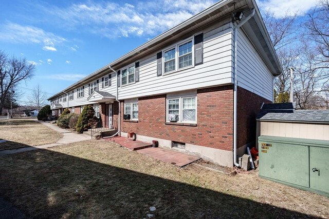 view of home's exterior with a lawn and brick siding