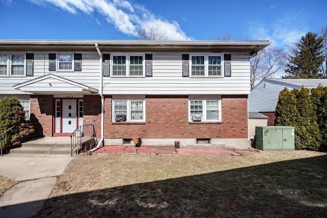 view of front of home with a front yard and brick siding