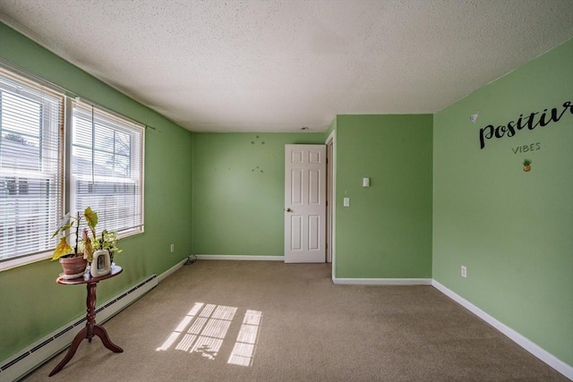 spare room with carpet flooring, a textured ceiling, a baseboard heating unit, and baseboards