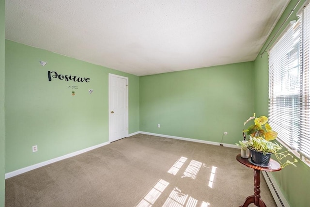 unfurnished room featuring baseboard heating, carpet flooring, and baseboards