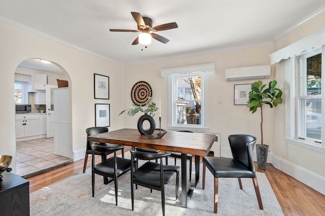 dining area featuring a wall unit AC, light hardwood / wood-style flooring, ceiling fan, and crown molding