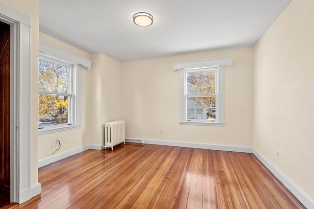 unfurnished room featuring light hardwood / wood-style floors and radiator