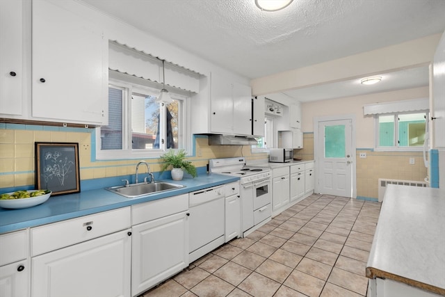 kitchen with white cabinetry, sink, white appliances, and radiator