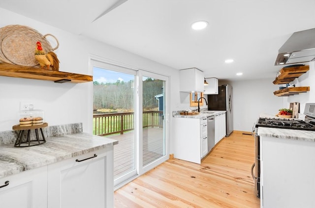 kitchen with light hardwood / wood-style floors, white cabinetry, and stainless steel dishwasher