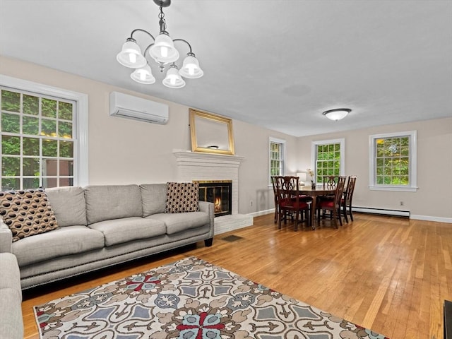 182 W Main St, Westborough, MA 01581 - living area with an AC wall unit, baseboard heating, wood finished floors, a chandelier, and baseboards