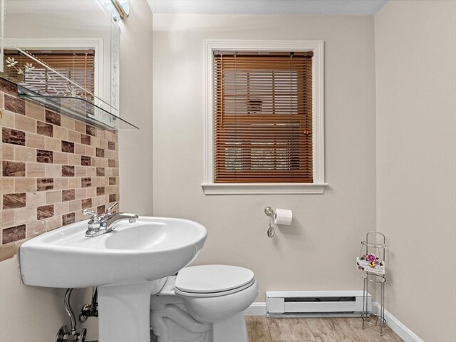 182 W Main St, Westborough, MA 01581 - half bathroom with a baseboard radiator, baseboards, decorative backsplash, toilet, and wood finished floors