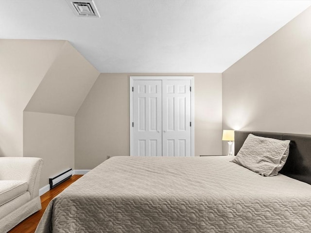 182 W Main St, Westborough, MA 01581 - bedroom with a baseboard heating unit, dark wood finished floors, baseboards, lofted ceiling, and a closet
