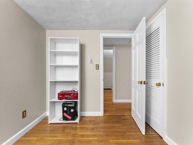 182 W Main St, Westborough, MA 01581 - bedroom with wood finished floors, baseboards, and a baseboard radiator