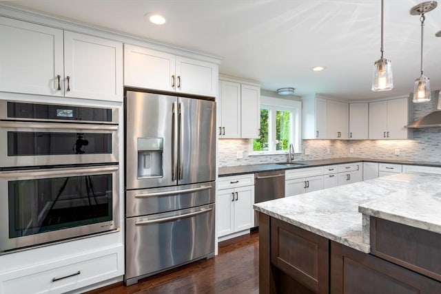 kitchen featuring decorative backsplash, white cabinets, appliances with stainless steel finishes, and light stone countertops