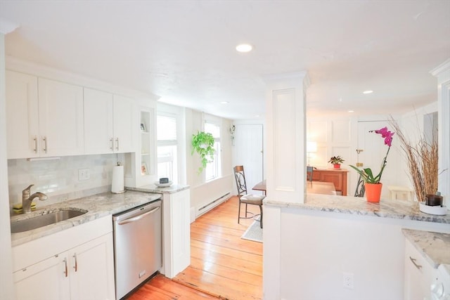 kitchen with light wood-style floors, a sink, stainless steel dishwasher, and white cabinets