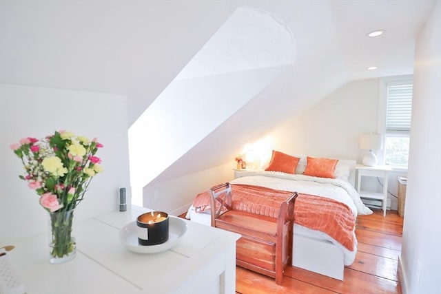 bedroom featuring a baseboard radiator, light wood-style flooring, recessed lighting, and vaulted ceiling